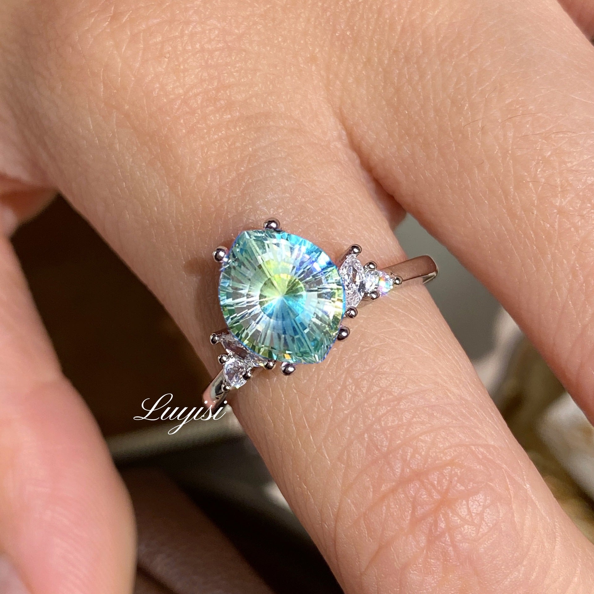 Firework-Cut Moissanite Ring in teal worn on finger, showing faceted stone sparkle