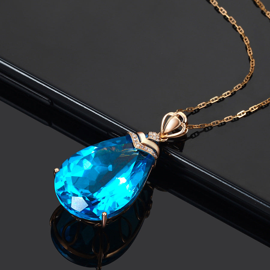 Blue Crystal Pendant Necklace, large teardrop-cut blue topaz with diamond bail, dark reflective background