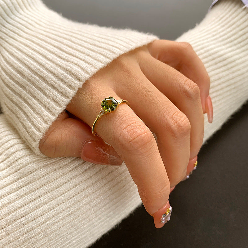 Gold Wedding Party Ring with round green gemstone, worn on hand