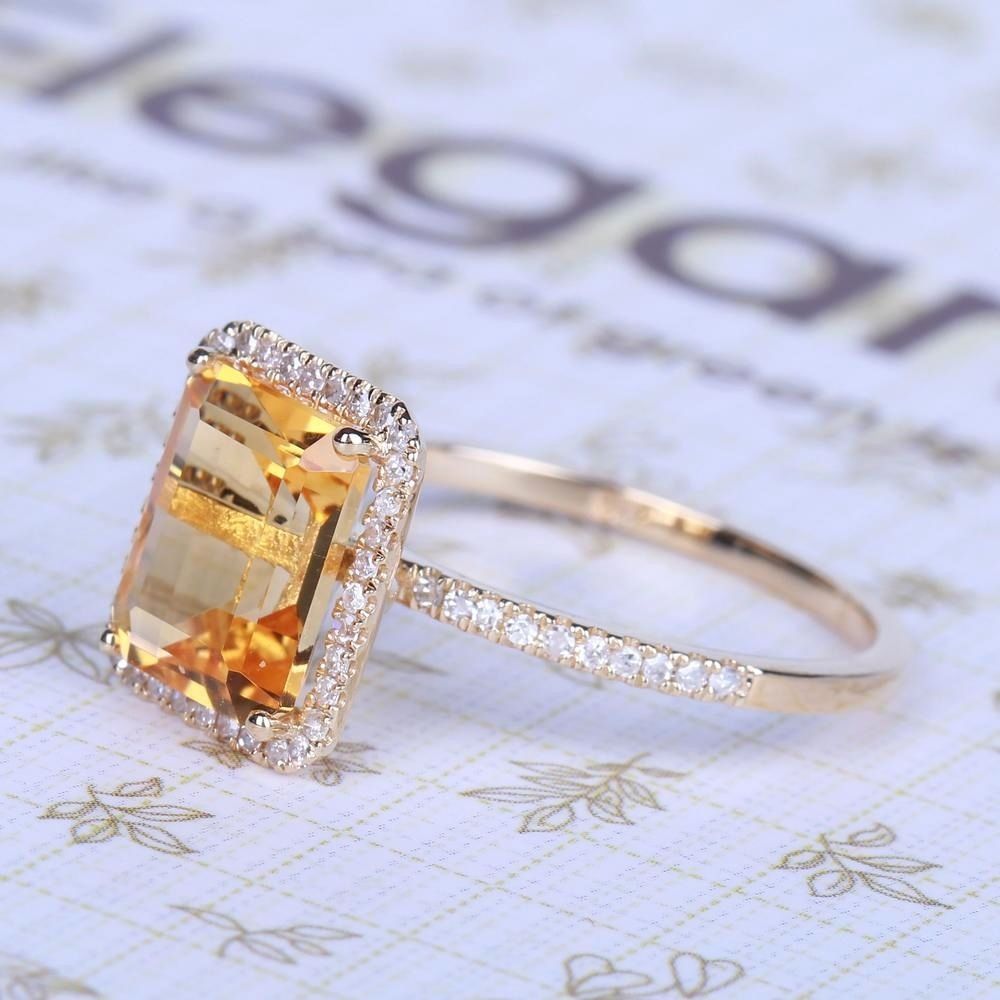Champagne Gemstone Engagement Ring resting on decorative fabric, emerald-cut stone with pave band