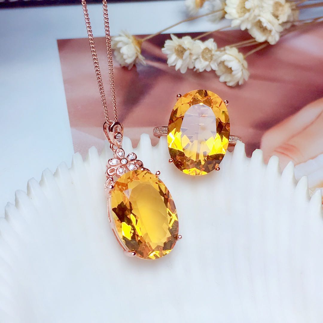 Crystal Pendant Necklace Set with matching ring, large yellow citrine gemstones, displayed on decorative dish