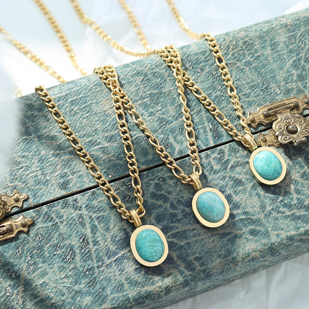 Three Amazonite Pendant Necklaces draped over a book, gold chains with amazonite stone pendants