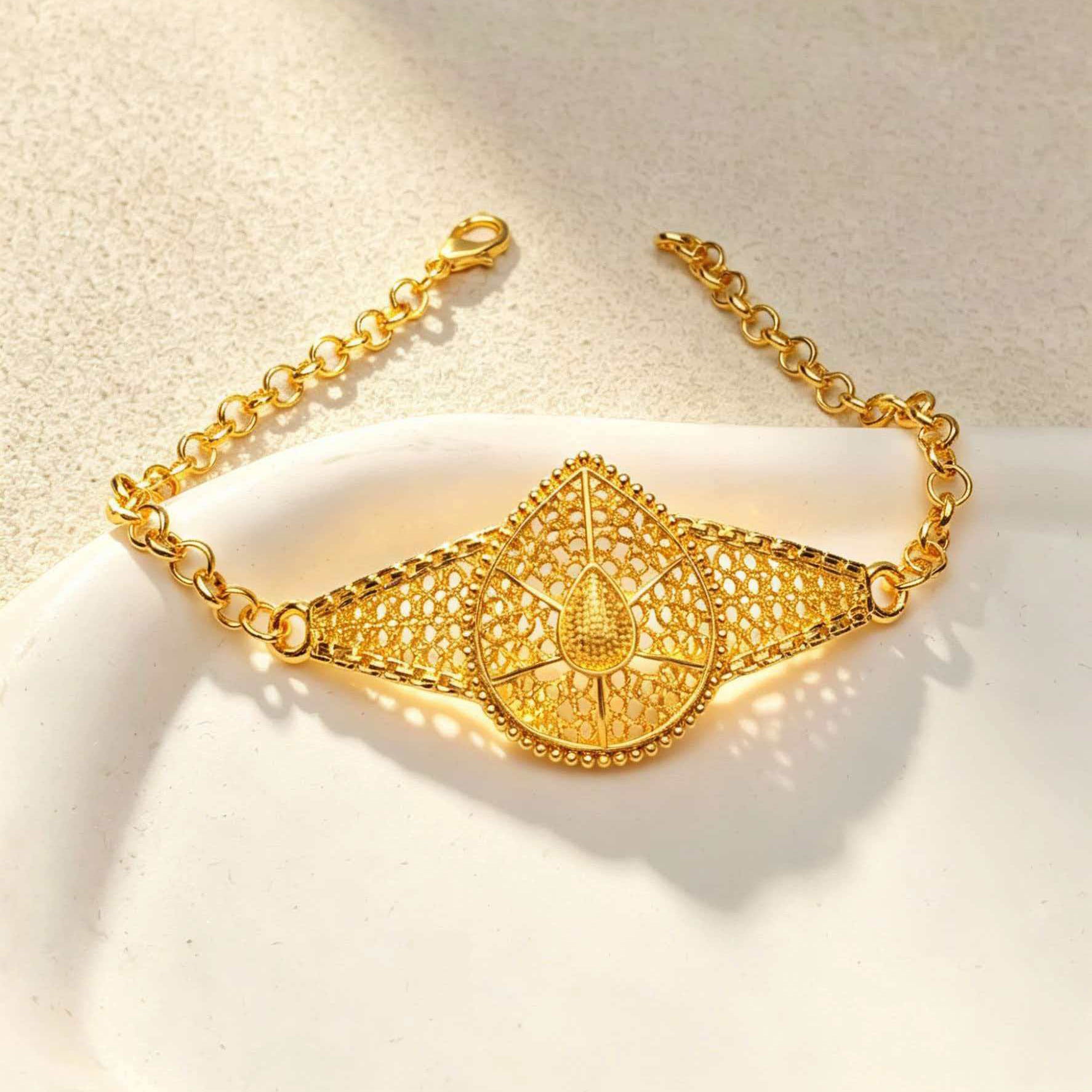 24K gold headpiece chain with filigree pendant detail, close-up on fabric