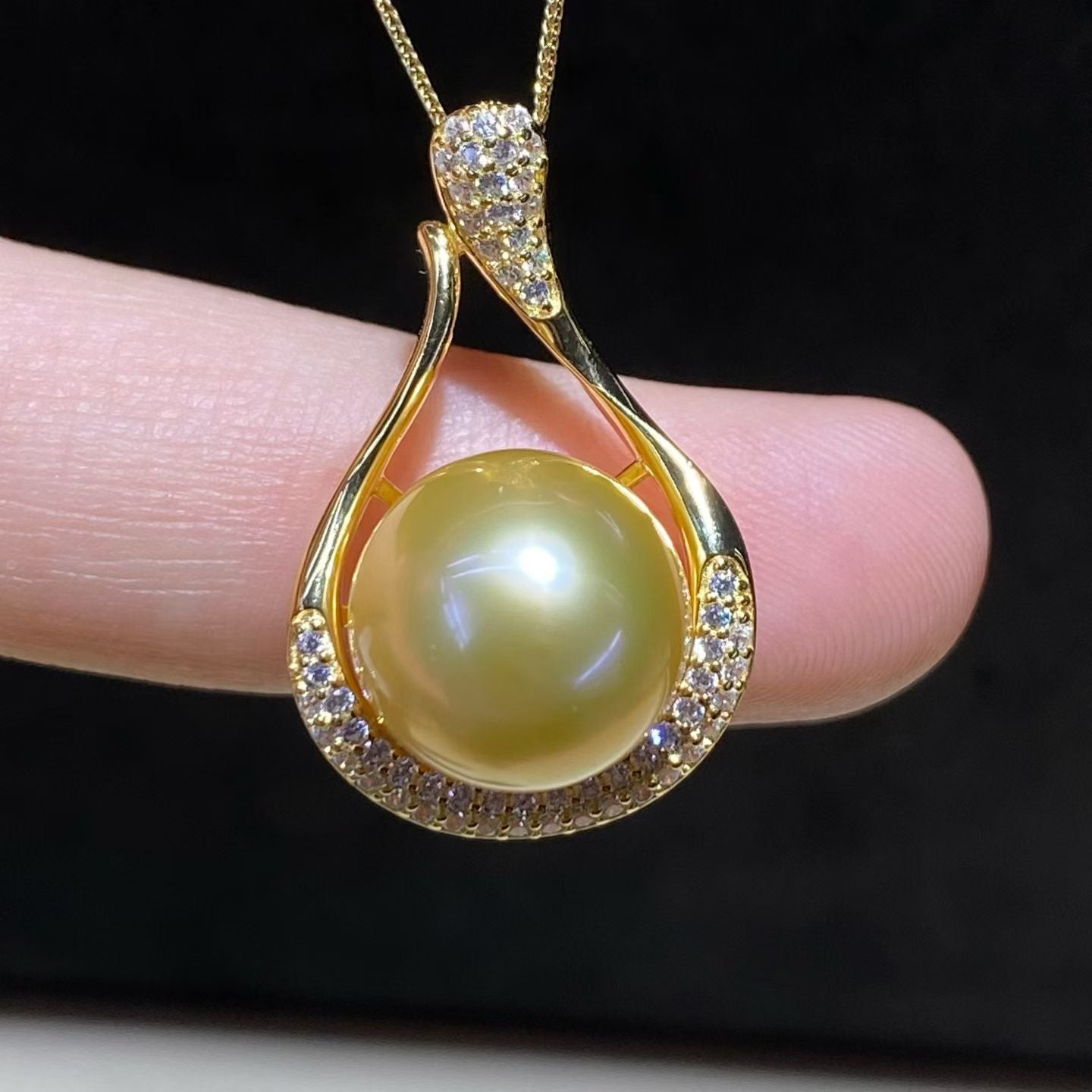 Close-up detail of golden South Sea pearl pendant showing luster and diamond halo