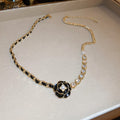 Camellia Pearl Pendant Necklace, black leather-wrapped chain with black camellia flower and crystals