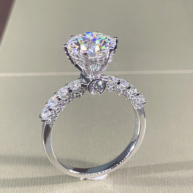 Six-Prong Moissanite Ring - front view of moissanite solitaire engagement ring with pave diamond band