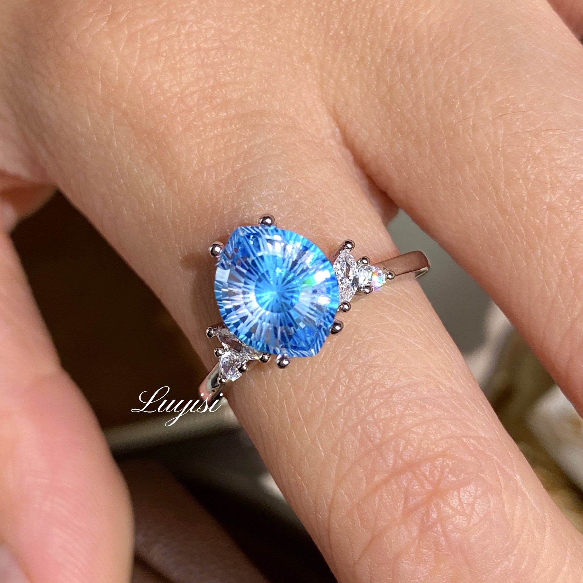 Firework-Cut Moissanite Ring in blue worn on finger, showing faceted stone sparkle