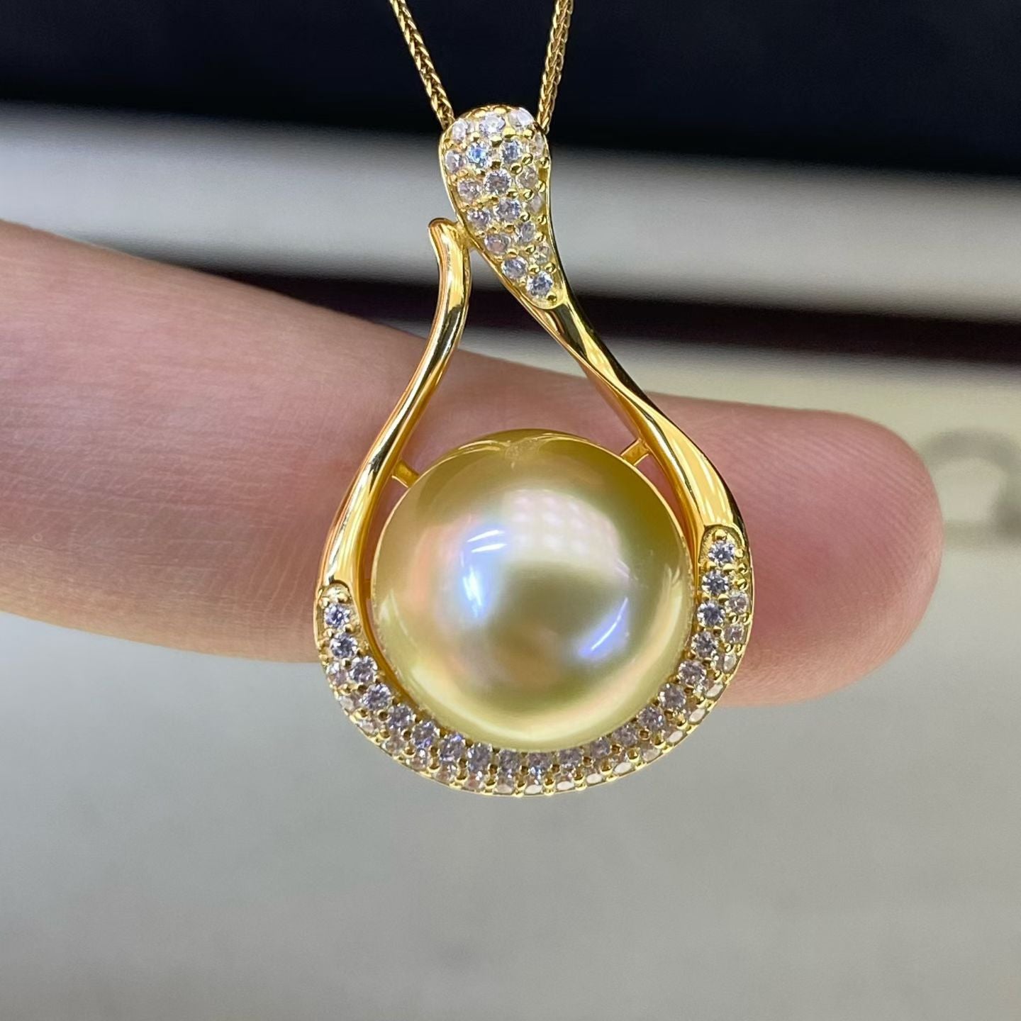 South Sea Pearl Necklace pendant held to the light, showing pearl surface highlights