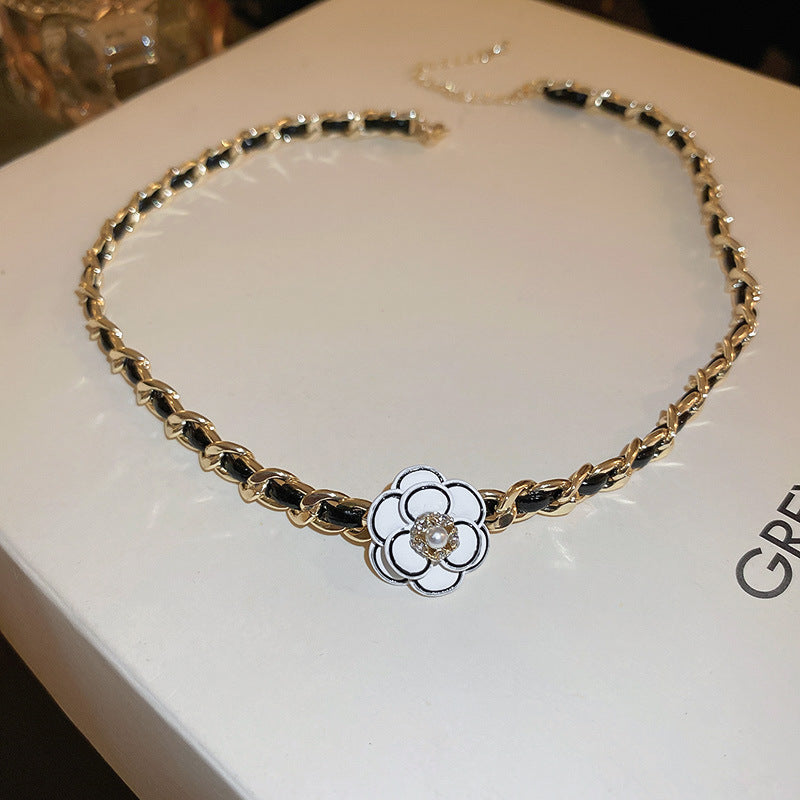 Camellia Pearl Pendant Necklace, gold and black leather-wrapped chain with white camellia flower centerpiece