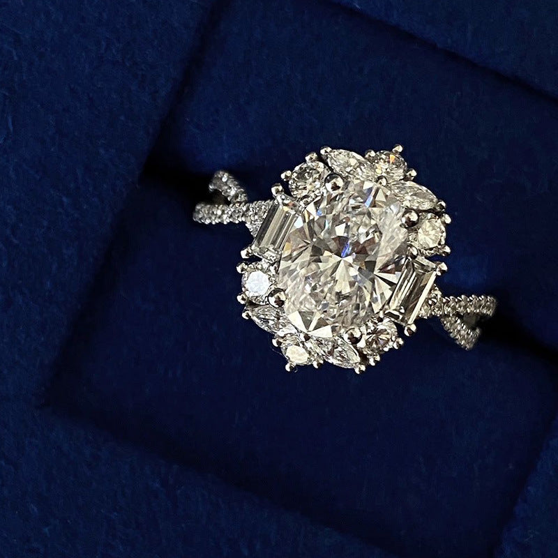 Oval Moissanite Cluster Ring on navy blue display box, angled view of the cluster setting